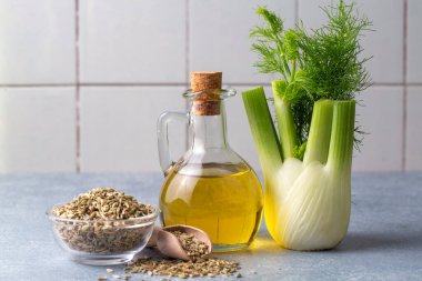 Taze yeşil rezene dalları ve rezene tohumlarıyla rezene yağı.