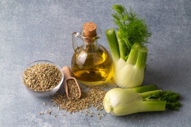 Taze yeşil rezene dalları ve rezene tohumlarıyla rezene yağı.