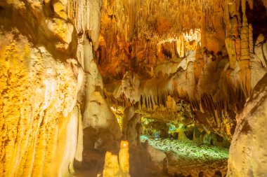 Damlatas Mağarası 'nda (Alanya, Türkiye) turuncu-sarı aydınlatmalı taş oluşumlar. Taş kalıplarının doğal soyut dokusu