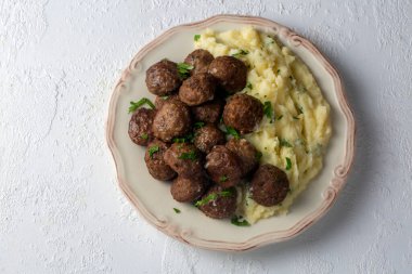 Yuvarlak şekilli köfteler ve patates püresi. Türkçe adı: kuru kofte ve patates puresi