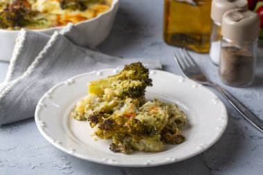 Casserole Cauliflower and broccoli baked with cheese sauce in a pot close-up on a wooden table. Horizontal top view from above. Broccoli gratin.