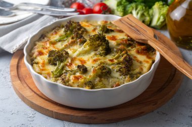 Casserole Cauliflower and broccoli baked with cheese sauce in a pot close-up on a wooden table. Horizontal top view from above. Broccoli gratin.