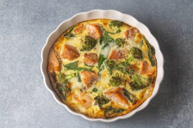 Yumurta bazlı frittata, somon, brokoli ve ıspanaklı omlet. İtalyan yemeği, yumurtalı, balıklı ve sebzeli kabuksuz kiş..