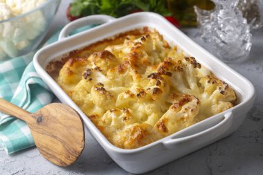 Casserole Cauliflower and broccoli baked with cheese sauce in a pot close-up on a wooden table. Horizontal top view from above. Broccoli gratin.