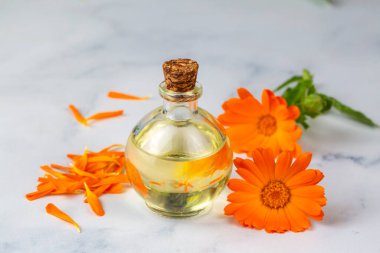 Bardakta bitkisel takvim ve yağ var. Calendula yağı.