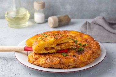 Spanish omelette with potatoes, typical spanish cuisine on gray concrete floor. Tortilla Espanola. Turkish name; Yumurtali patates