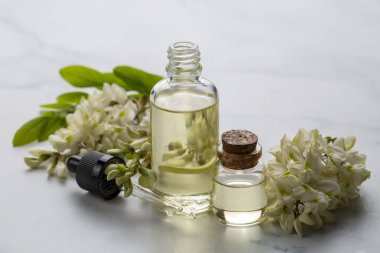 Robinia (sahte akasya) esaslı yağ (çare, özü) şişesi taze akasya çiçekleri ile
