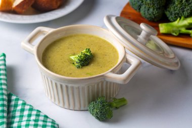 Yeşil çorba. Kremalı ve parmesanlı brokoli kremalı çorba. Sağlıklı vejetaryen yemeği. Beyaz masadaki üst görünüm.