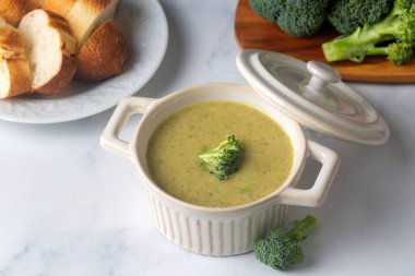Yeşil çorba. Kremalı ve parmesanlı brokoli kremalı çorba. Sağlıklı vejetaryen yemeği. Beyaz masadaki üst görünüm.