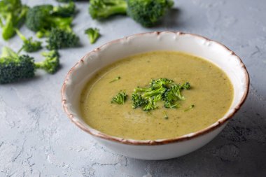 Yeşil çorba. Kremalı ve parmesanlı brokoli kremalı çorba. Sağlıklı vejetaryen yemeği. Beyaz masadaki üst görünüm.