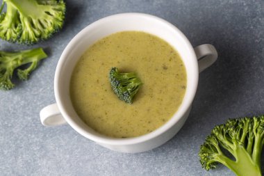 Yeşil çorba. Kremalı ve parmesanlı brokoli kremalı çorba. Sağlıklı vejetaryen yemeği. Beyaz masadaki üst görünüm.