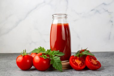 Tomato juice in a glass and fresh tomatoes