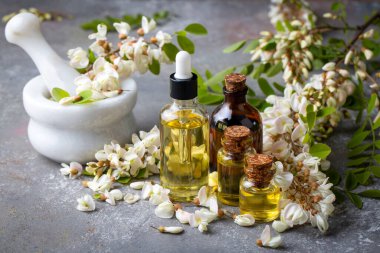 Robinia (sahte akasya) esaslı yağ (çare, özü) şişesi taze akasya çiçekleri ile
