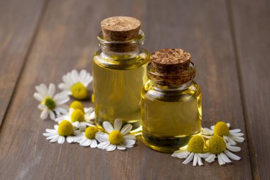 Cam şişedeki temel yağ taze papatya çiçekleri, güzellik tedavisi. Daisy yağı. 