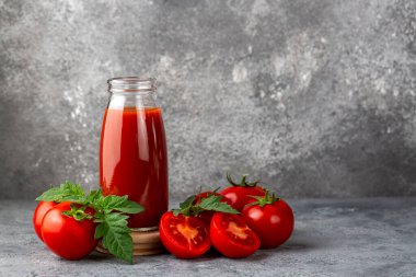 Tomato juice in a glass and fresh tomatoes
