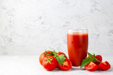 Tomato juice in a glass and fresh tomatoes