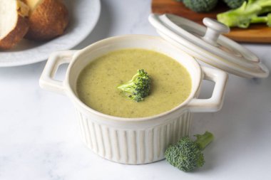 Yeşil çorba. Kremalı ve parmesanlı brokoli kremalı çorba. Sağlıklı vejetaryen yemeği. Beyaz masadaki üst görünüm.