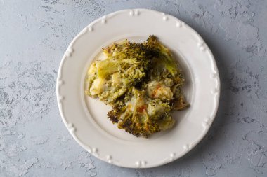 Casserole Cauliflower and broccoli baked with cheese sauce in a pot close-up on a wooden table. Horizontal top view from above. Broccoli gratin.