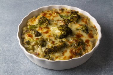 Casserole Cauliflower and broccoli baked with cheese sauce in a pot close-up on a wooden table. Horizontal top view from above. Broccoli gratin.