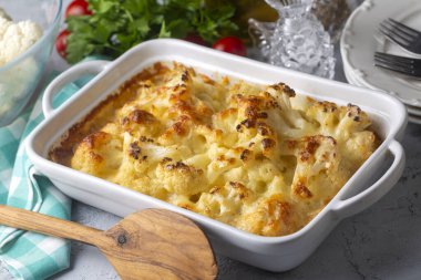 Peynir sosunda pişirilmiş karnabahar ve brokoli. Tahta bir masaya yakın çekim. Yukarıdan yatay üst görünüm. Brokoli graten..