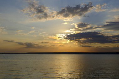 Denizde gün batımı manzarası ve gökyüzünde bulutlar. Akbuk - Aydın - Türkiye