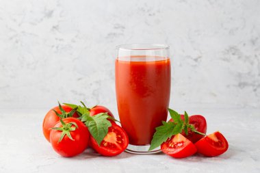 Tomato juice in a glass and fresh tomatoes