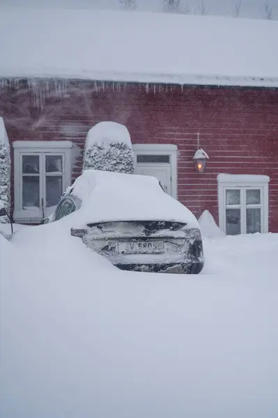 ノルウェーのトンズバーグ 2024年1月1日 オレンジ色の赤いヒュンダイ イオニクの電気自動車が雪の下に降りました スノーストーム 雪の送風機で雪を除去する ストック画像