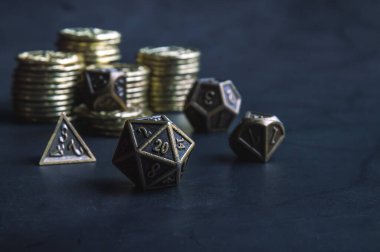 Metalik RPG zar ve altın sikkelerin yakın plan görüntüsü