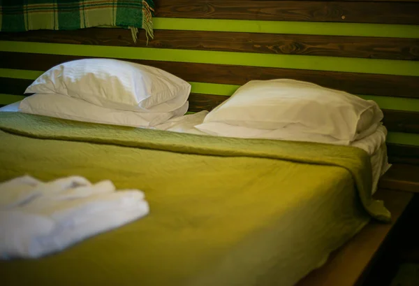 宾馆房间里的一张绿色的床已经为游客准备好了 — 图库照片