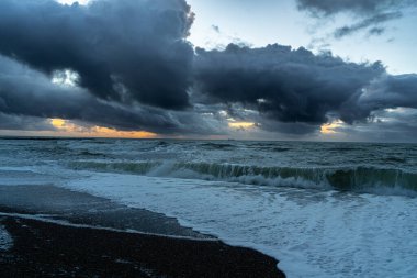 Panoramic view of Baltic sea from sandy shore, sand dunes. Dramatic sky with glowing clouds, sunbeams.