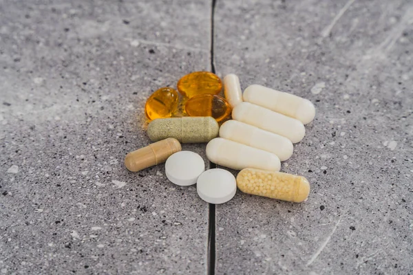 Assorted pharmaceutical medicine pills, tablets and capsules.Pills background. Heap of assorted various medicine tablets and pills different colors on stone background. Health care.Top view.