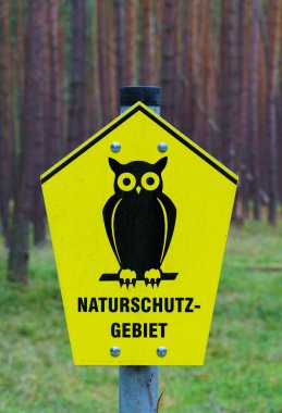 Brandenburg 'daki Ulusal Park Çekirdek Bölgesi' ni imzalayın. Sarı arka planı olan sembol baykuşu. Uyarı işareti, uyarı işareti. Detaylı çekim