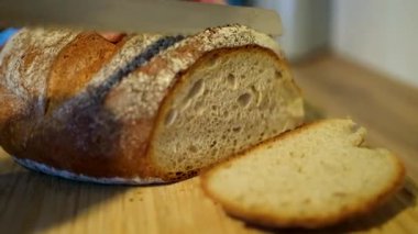 Zanaatkar ekmeği güzel bir şekilde sade ahşap bir tahtanın üzerinde dizilmiş, çekici dokusunu ve kabuğunu sergiliyor.