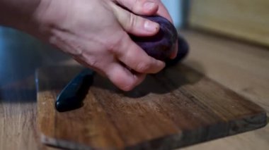 Kırsal ahşap bir kesme tahtasına yerleştirilmiş rengarenk erikler, zengin renklerini sergiliyor.