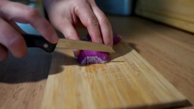 Renkli mor soğanlar, dilimlenmiş ve sade bir kesim tahtasına yerleştirilmiş, yemek ve yemek fotoğrafçılığı için mükemmel.