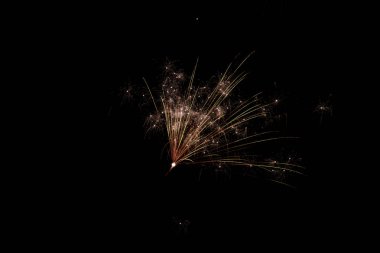 Çarpıcı kırmızı ve yeşil havai fişekler bir kutlama etkinliği sırasında gökyüzünü aydınlatıyor.