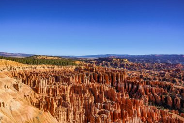 Bryce Canyons 'un göz kamaştırıcı güzelliğini keşfedin. Canlı kaya oluşumları ve çevresini saran yemyeşil alanlar.