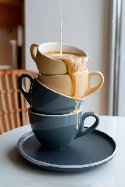 Coffee drink pours in a trickle into cups and pours out