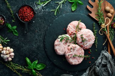 Çiğ domuz pirzolası. Baharatlı krep. Taş bir tahtanın üzerinde. Siyah bir arka planda. Üst görünüm.