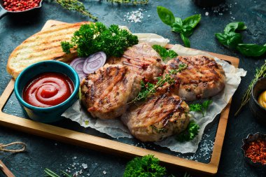 Barbekü: domuz pastırması ve soslu ızgara köfte. Taş bir tahtanın üzerinde. Üst görünüm.