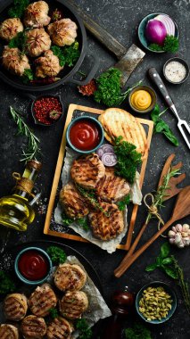 Barbekü: domuz pastırması ve soslu ızgara köfte. Taş bir tahtanın üzerinde. Üst görünüm.