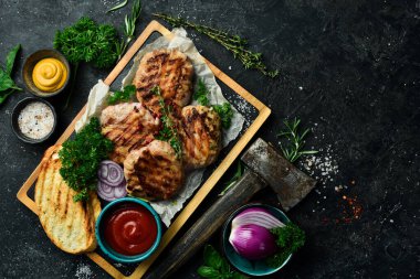 Barbekü: domuz pastırması ve soslu ızgara köfte. Taş bir tahtanın üzerinde. Üst görünüm.