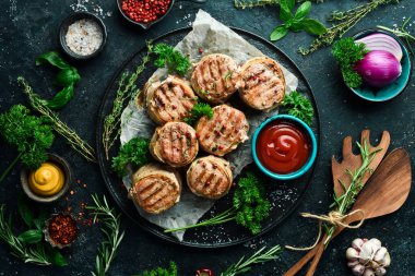 Pastırmaya sarılmış ızgara madalyon. Bir tavada, yemeye hazır. Siyah beton bir arka planda. Üst görünüm.