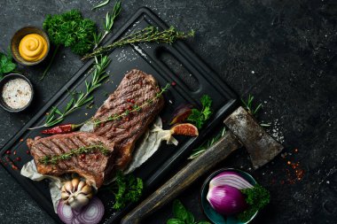 Barbekü. Baharatlı ve biberiyeli ızgara biftek. Siyah beton bir arka planda. Metin için boş alan.