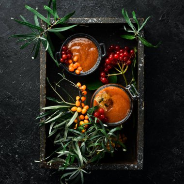 Reçel. Viburnum böğürtlen ve ballı deniz dikeni. Karanlık bir arka planda yüksek içerikli C vitamini içeren yiyecekler. en üstteki görünüm