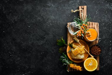 Sonbahar menüsü konsepti. Tatlım, deniz dikenleri ve turunçgiller. Karanlık bir arka planda. Üst görünüm.