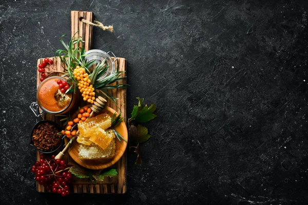 Reçel. Viburnum böğürtlen ve ballı deniz dikeni. Karanlık bir arka planda yüksek içerikli C vitamini içeren yiyecekler. en üstteki görünüm