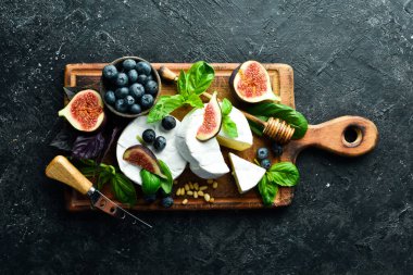 Tahtada Brie peyniri. Peynirli peynir ve ballı incir. Mesaj için yer var. Üst görünüm.