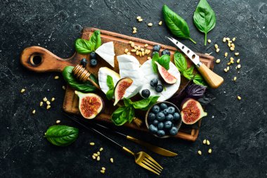 Tahtada Brie peyniri. Peynirli peynir ve ballı incir. Mesaj için yer var. Üst görünüm.