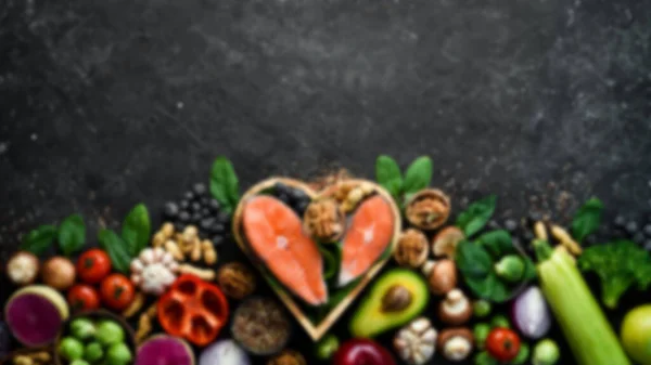 Defocused food background. Black stone cooking background. Spices and vegetables. Top view. Free space for your text.